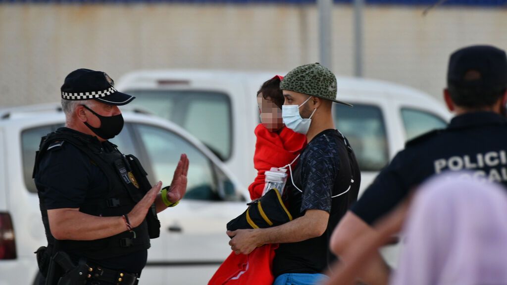 EuropaPress_3717565_policia_junto_hombre_migrante_coge_brazos_nina_playa_tarajal_17_mayo_2021