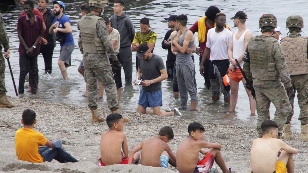 Miembros del Ejército de Tierra vigilan a un grupo de inmigrantes que han logrado cruzar