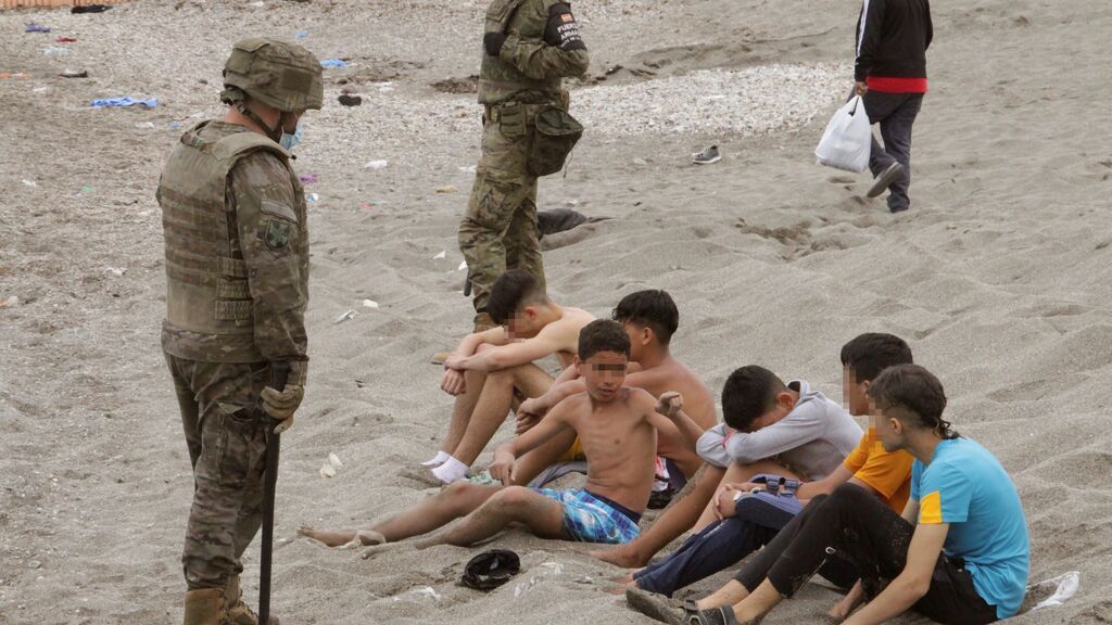 Miembros del Ejército de Tierra vigilan a un grupo de inmigrantes menores que han logrado cruzar