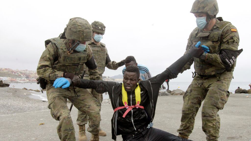 Miembros del Ejército de Tierra ayudan a un inmigrante que ha logrado cruzar