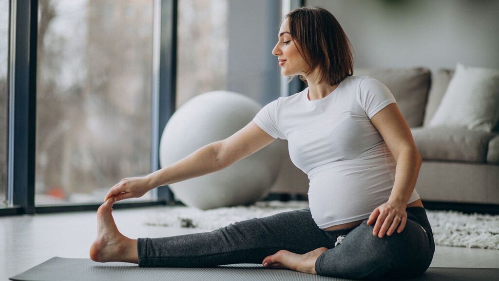 young-pregnant-woman-practicing-yoga-at-home