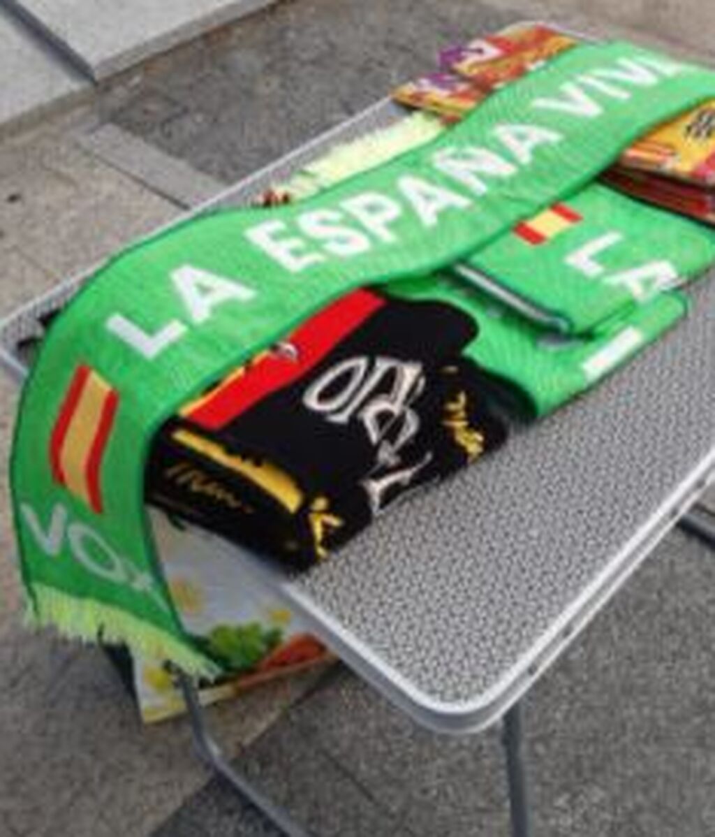 Puesto de 'merchandising' con bufandas de Vox