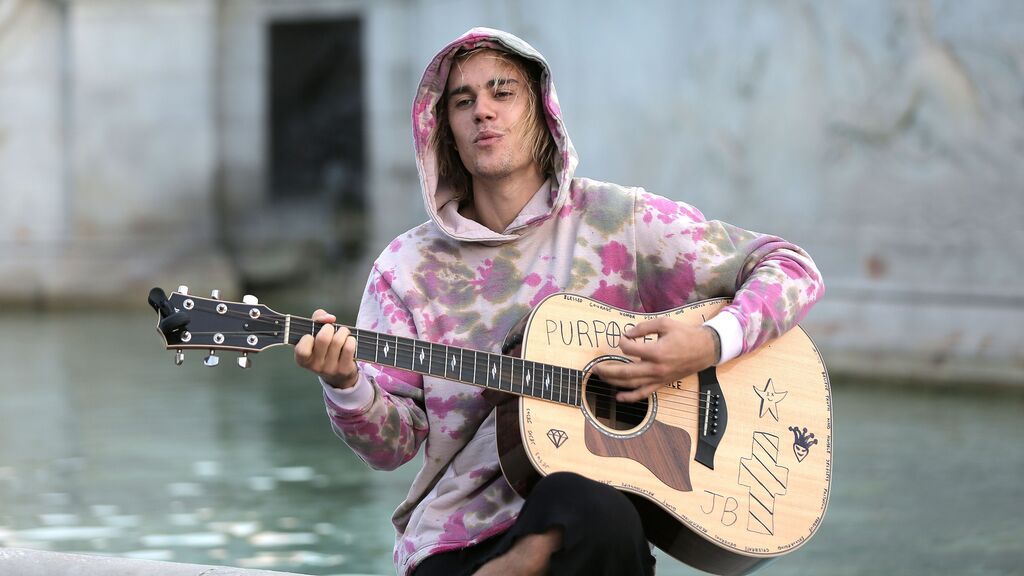 Justin Bieber toca la guitarra con su mano izquierda.