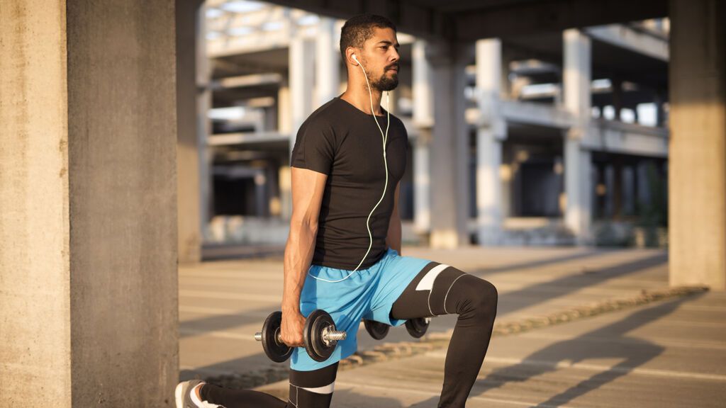 sportsman-listening-to-music-and-training-with-weights