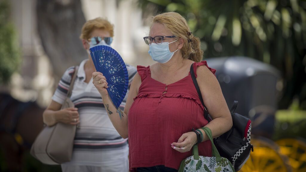Una mujer utiliza abanico para combatir el calor
