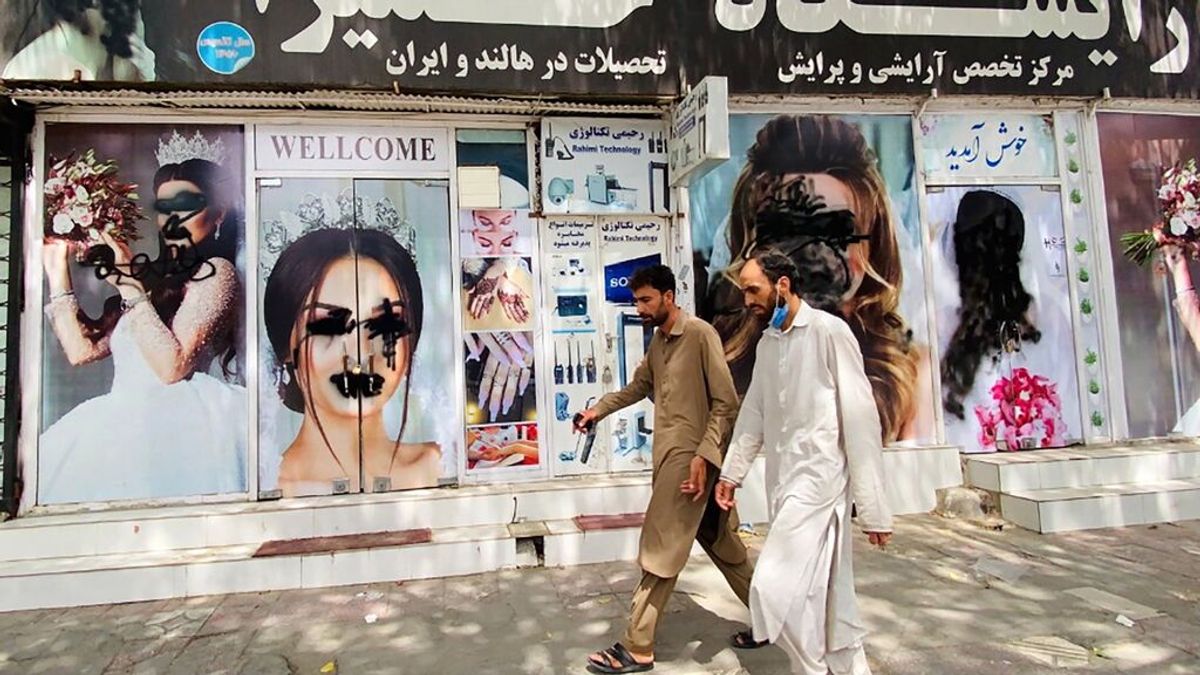 Dos hombres pasan frente a un salón de belleza en Kabul