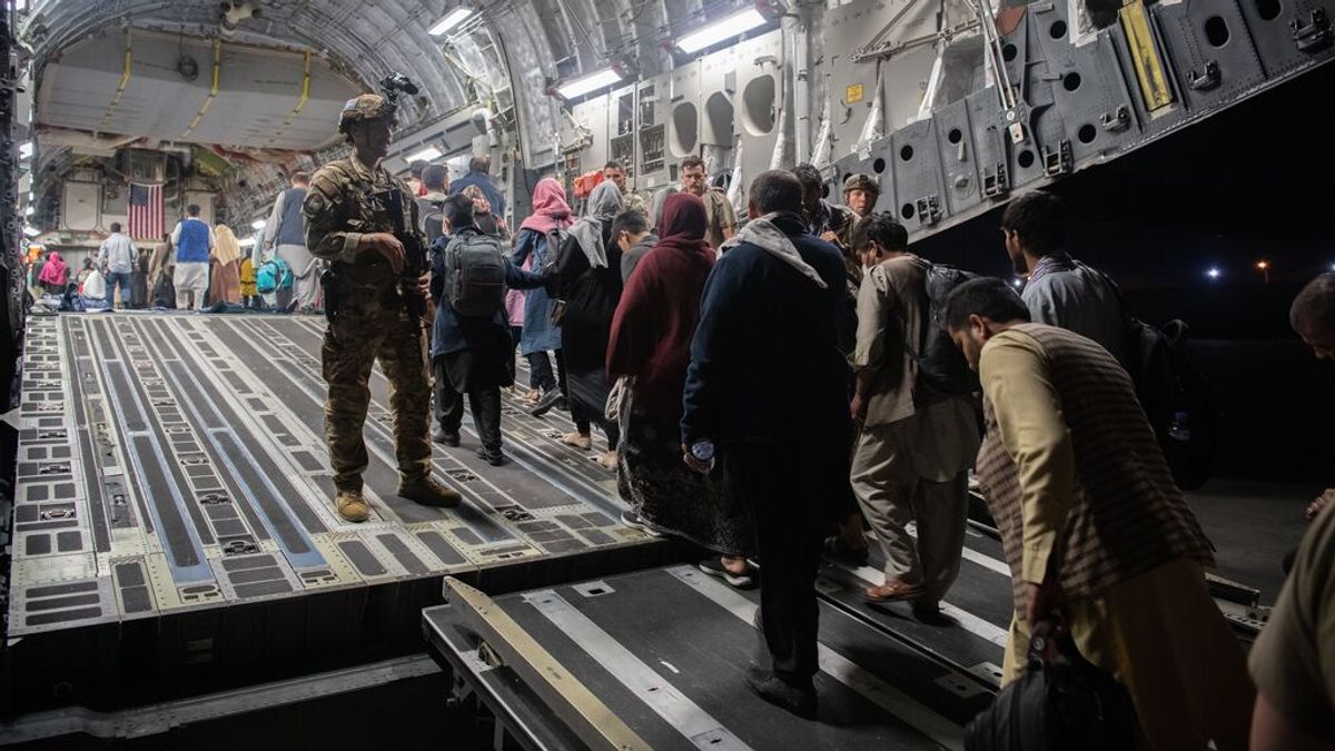 Refugiados afganos suben a un avión estadounidense Refugiados afganos suben a un avión estadounidense