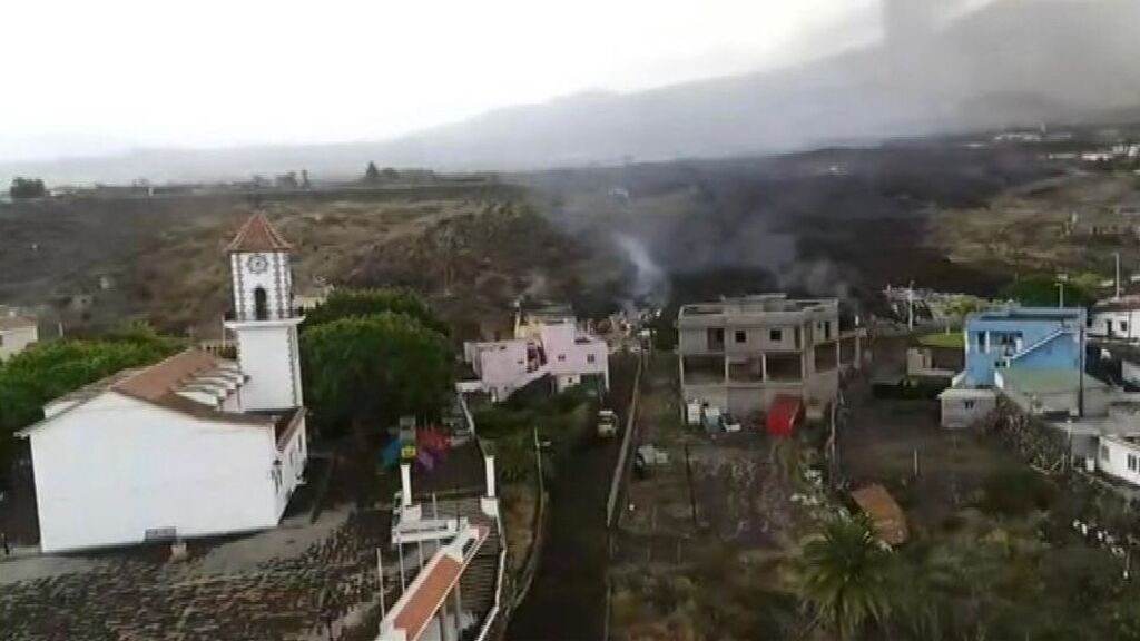 Los bomberos intentan desviar la lava con una excavadora para salvar la iglesia de Todoque