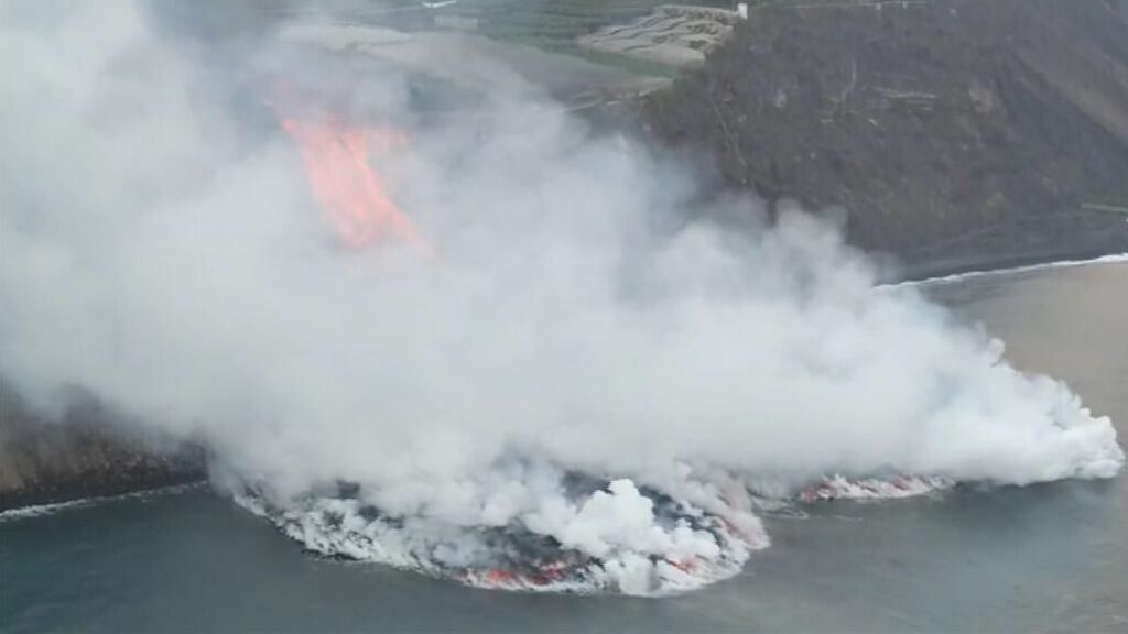 La luz del día permite ver cómo la lava llega al mar y la gran columna de vapor de agua