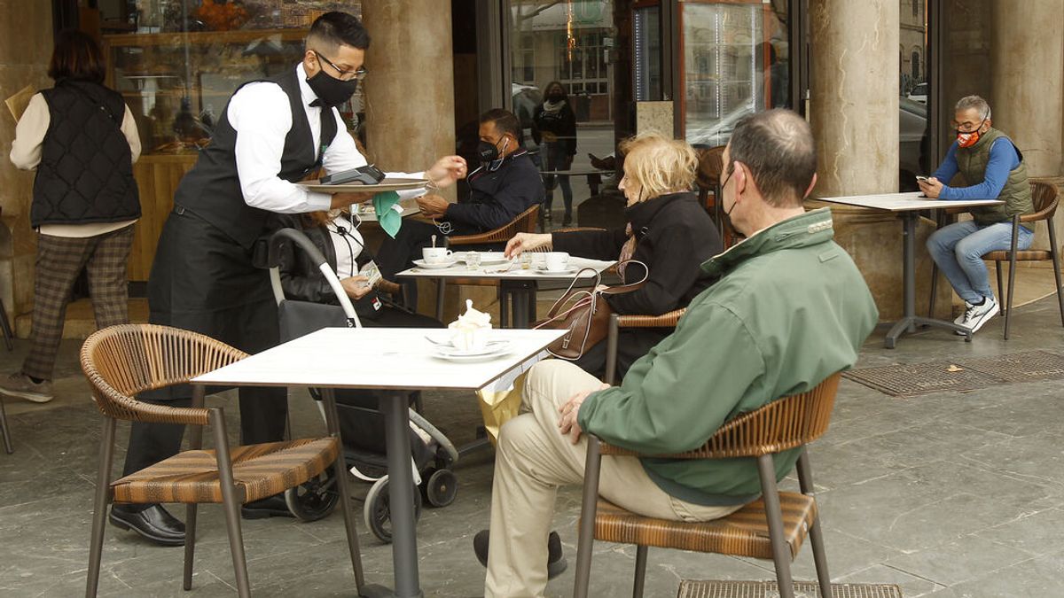 Un camarero atiende a varios clientes en la terraza de un bar en Palma Un camarero atiende a varios clientes en la terraza de un bar en Palma