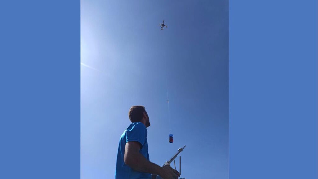 Eduardo Díaz manipula en dron con agua para llevarla a los perros aislados por la lava.