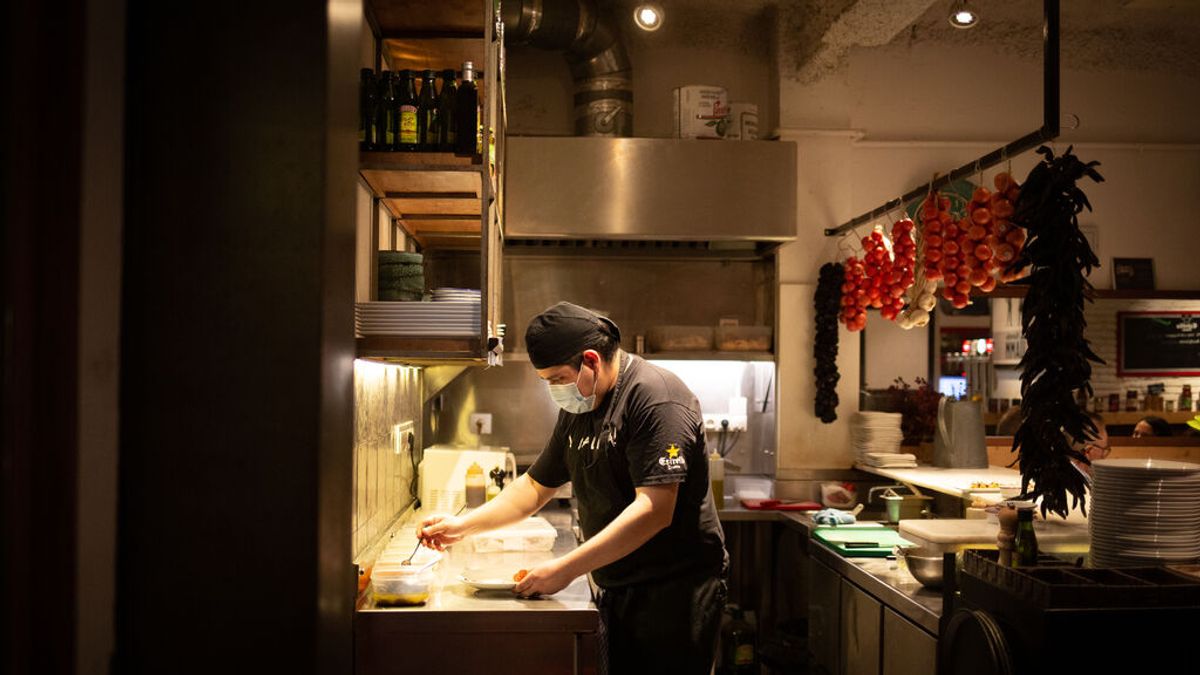 Un cocinero en el interior de un bar en una calle de Barcelona Un cocinero en el interior de un bar en una calle de Barcelona