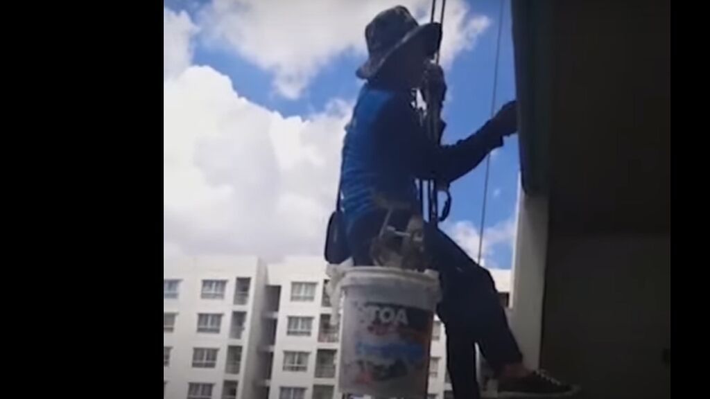 Una mujer corta la cuerda que sostenía a dos pintores en un edificio y los deja colgando a 26 pisos de altura