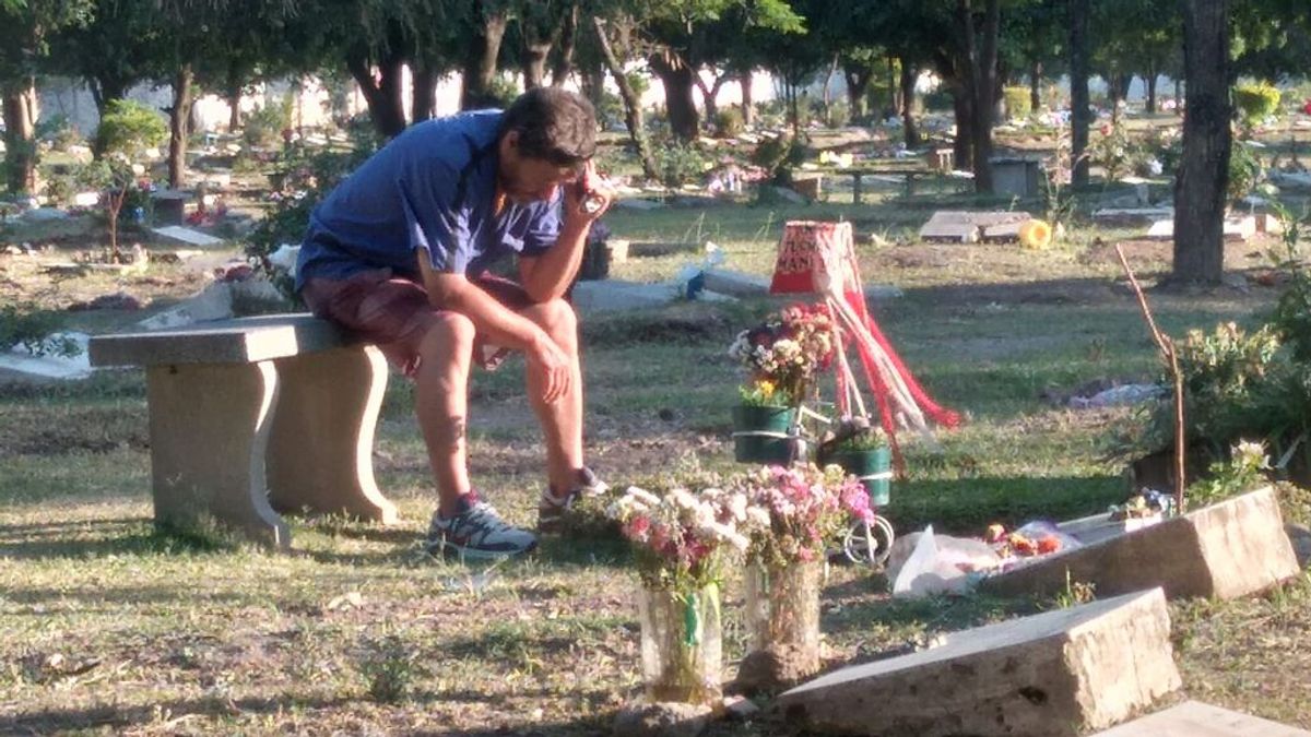 La desgarradora fotografía de un padre escuchando un partido de fútbol junto a la tumba de su hijo