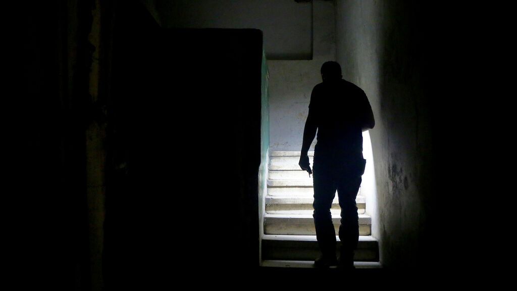 Un hombre enciende la linterna ante un apagón eléctrico