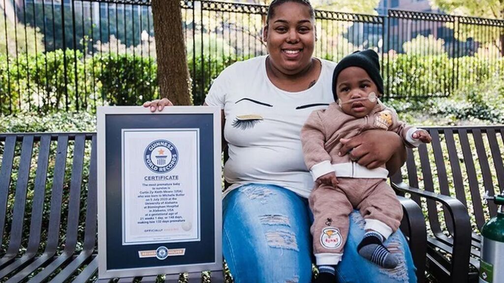 Curtis junto a su madre, con el diploma que le convierte en un niño prematuro de Récord Guinness