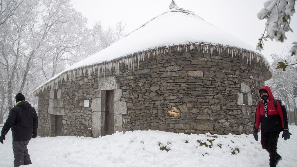 Dos personas caminan entre la nieve este domingo en O Cebreiro