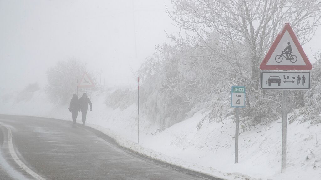 Dos personas caminan entre la nieve este domingo en O Cebreiro.