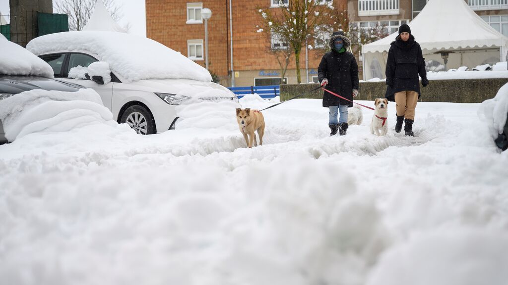 Dos personas caminan este domingo sobre la nieve acumulada