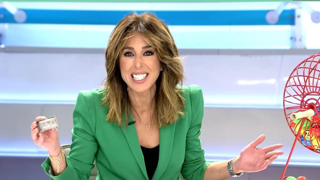 La presentadora muestra su amuleto y anima a su compañera a dar el gordo