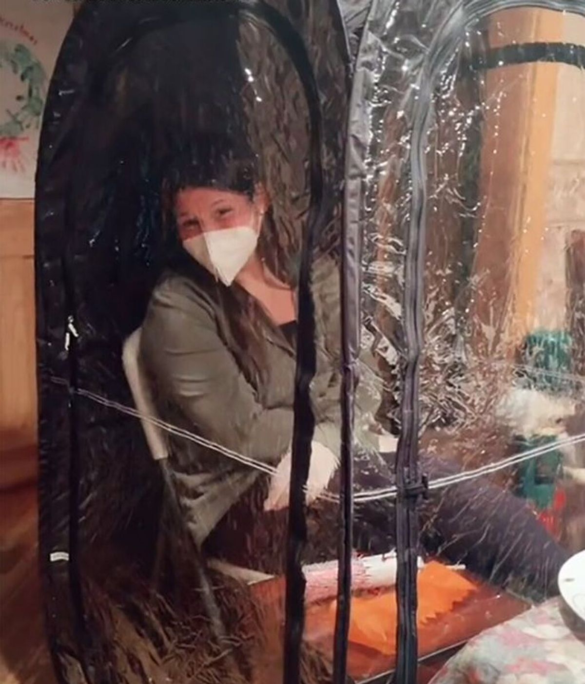 Una joven con coronavirus se encierra en una burbuja de plástico para cenar con su familia en Navidad