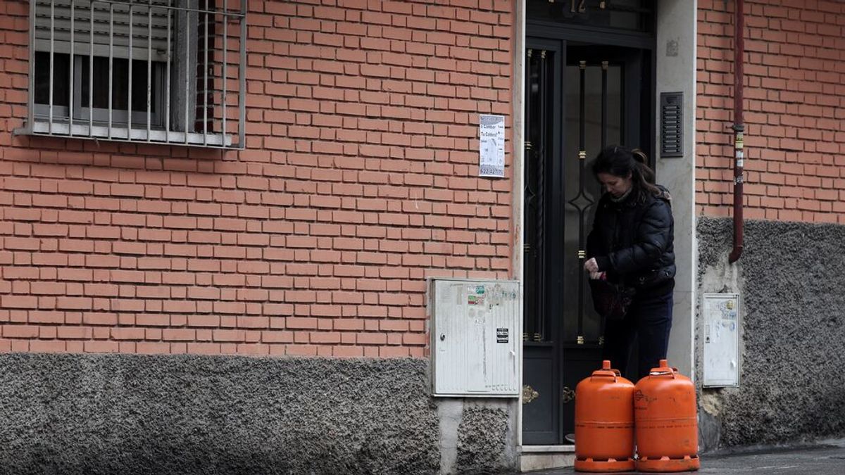 Una mujer con dos bombonas de butano Una mujer con dos bombonas de butano