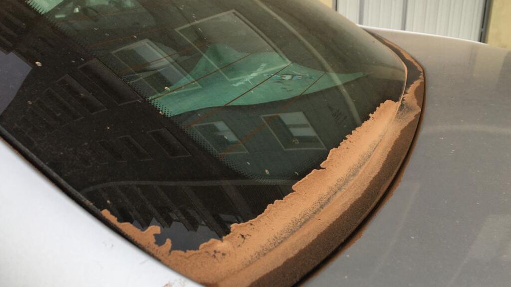 Un coche cubierto de polvo.