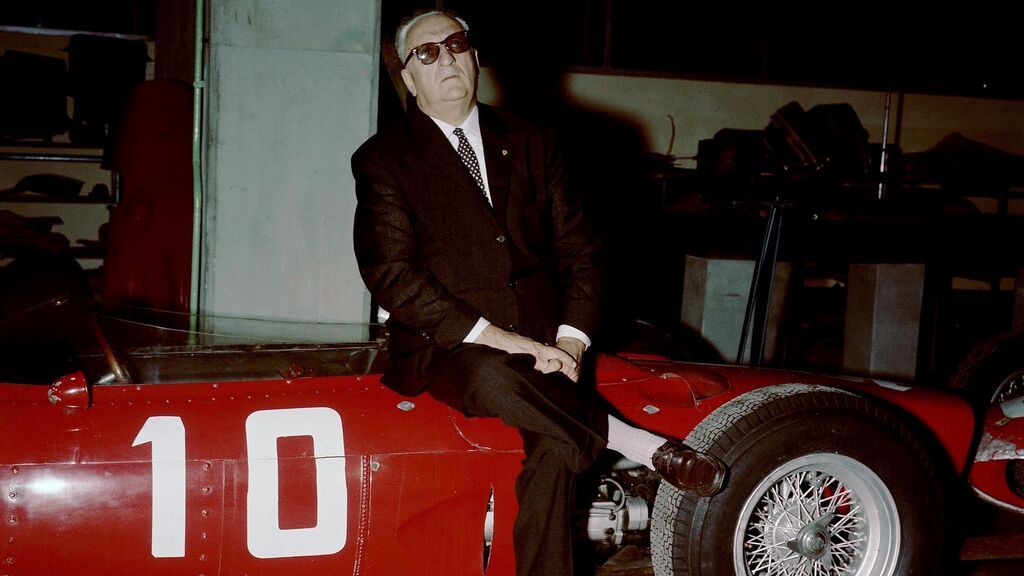 Enzo Ferrari sentado en un monoplaza.