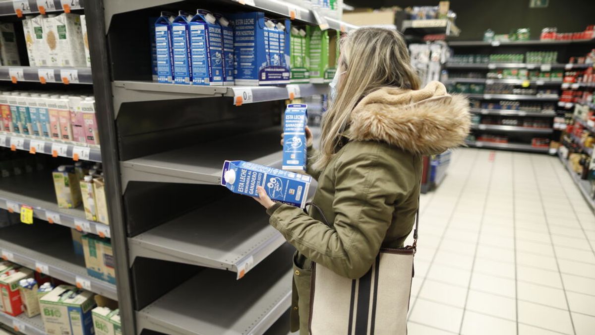Una persona ante una estantería de un supermercado Una persona ante una estantería de un supermercado