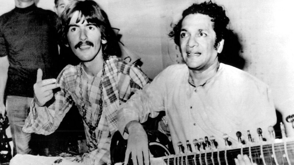 George Harrison junto a Ravi Shankar tocando el sitar.