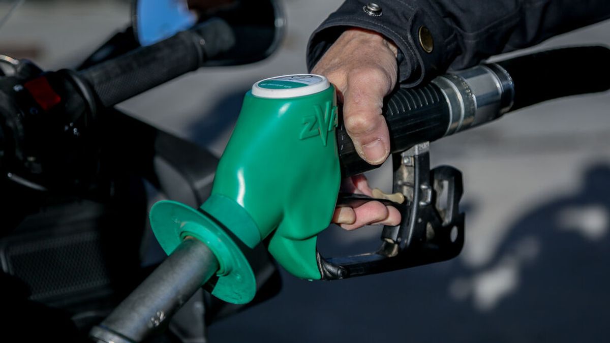 Una persona pone gasolina en su vehículo Una persona pone gasolina en su vehículo