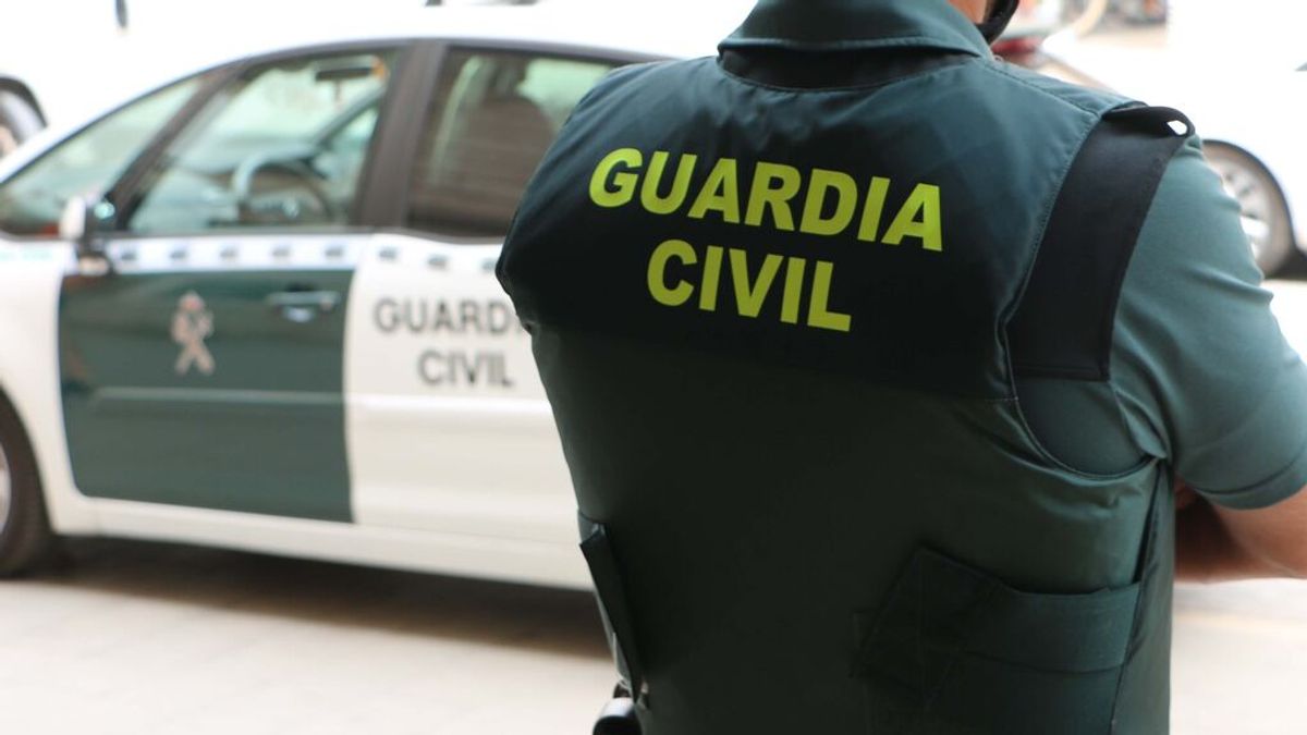 EuropaPress_4256421_agente_guardia_civil_espaldas_junto_vehiculo_oficial