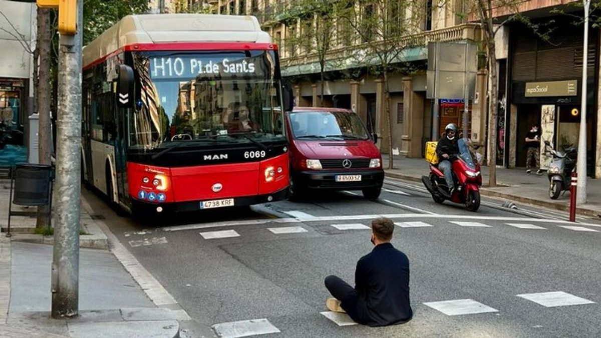 Un joven pierde el autobús y se sienta en medio de la calle para impedir su paso como protesta en Barcelona