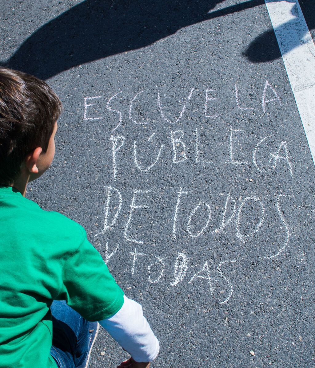 Un menor pinta en el asfalto