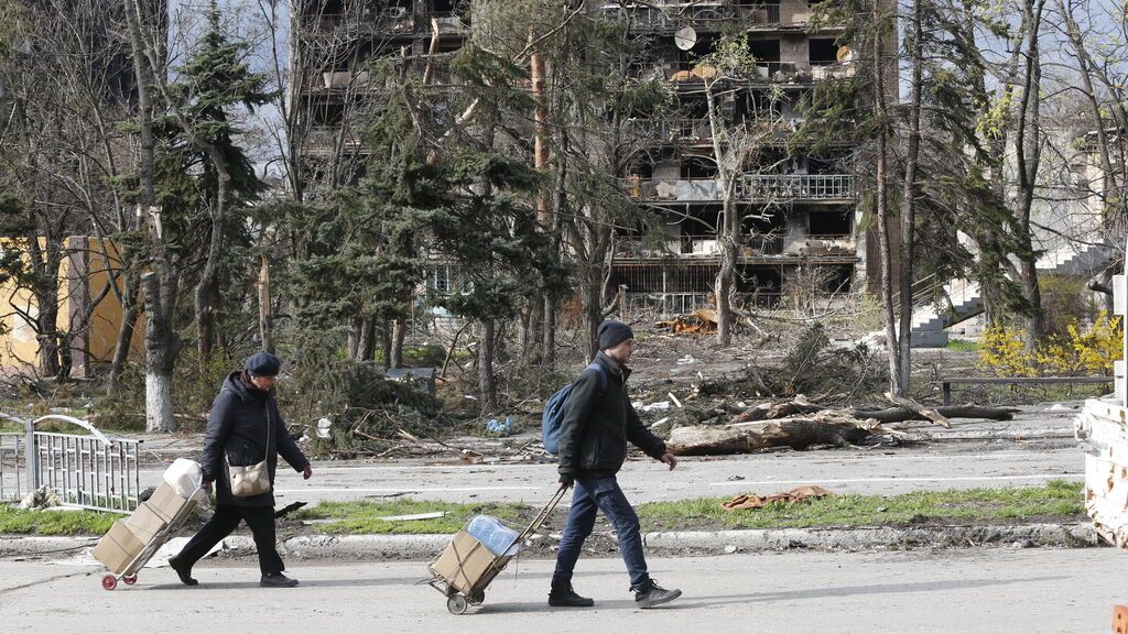 EuropaPress_4401585_mariupol_april_23_2022____people_walk_near_damaged_building_in_the_port