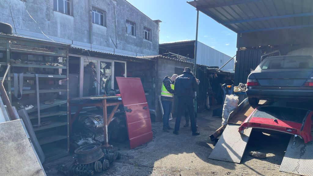Los agentes, durante el registro en el desguace.