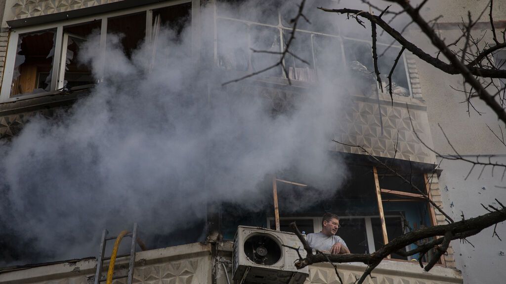 EuropaPress_4431310_may_2022_kharkiv_ukraine_man_looks_out_window_while_firefighters_extinguish
