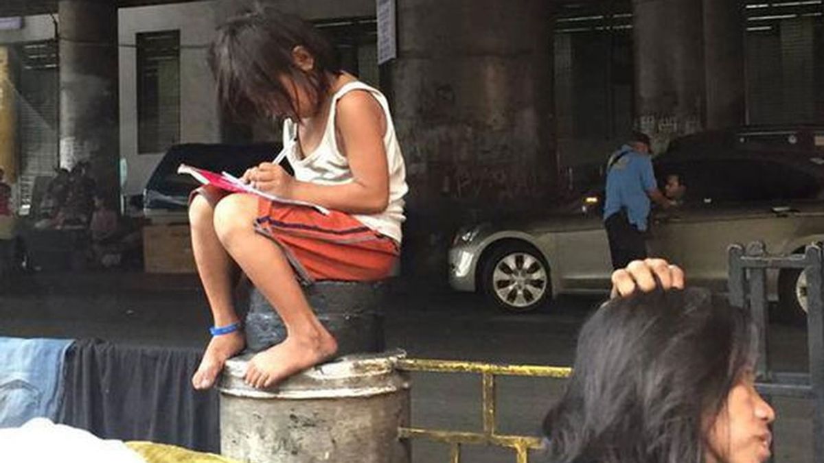 La imagen de una niña filipina haciendo los deberes en la calle conmociona la Red