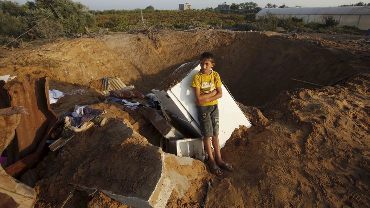 Niño palestino junto a los restos que ha dejado el ataque israelí