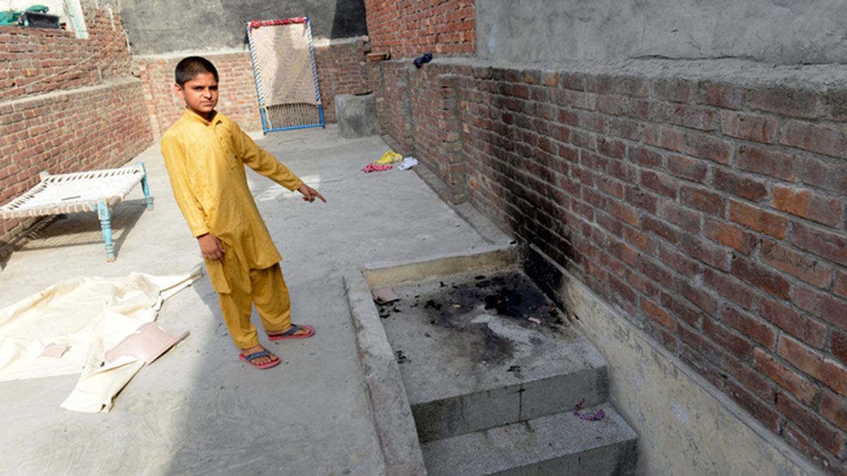Un niño muestra el lugar donde una adolescente ha sido quemada viva por su madre en Lahore, Pakistán