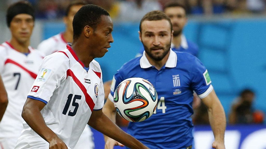 El primer tiempo se jugó en medio campo. Díaz intenta sacar un balón ante Salpinguidis