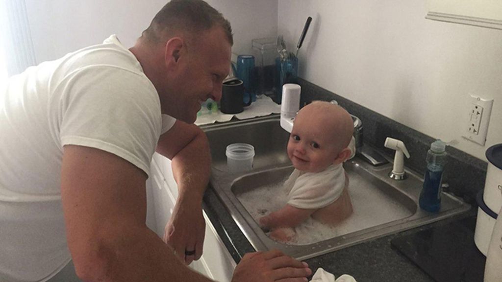 Dos policías dan un baño especial a un bebé al que encontraron cubierto en vómitos