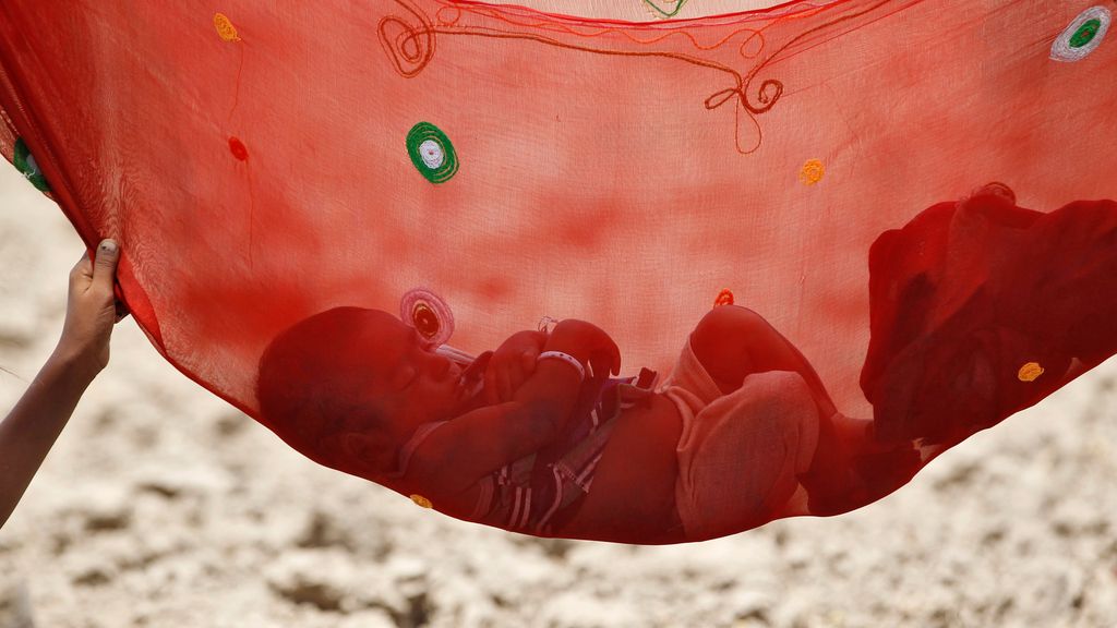 Un bebé duerme en una hamaca en la India