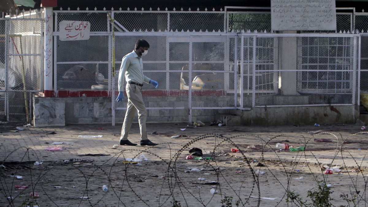 Un forense examina el parque de Lahore tras el atentado