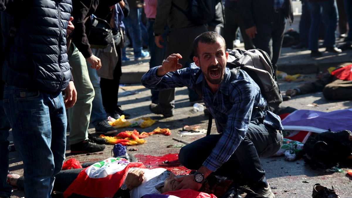 Un hombre junto a uno de los cientos de cadáveres de Ankara