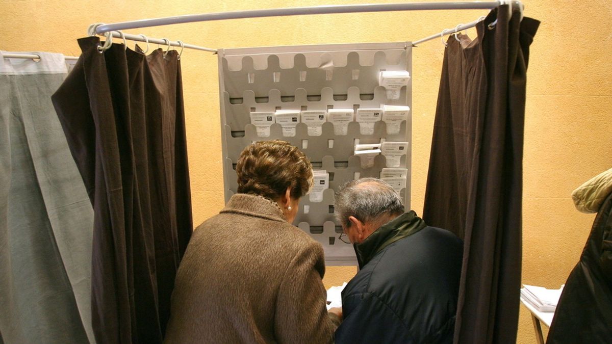 Dos personas preparan sus papeletas esta mañana en un colegio electoral en Tarragona