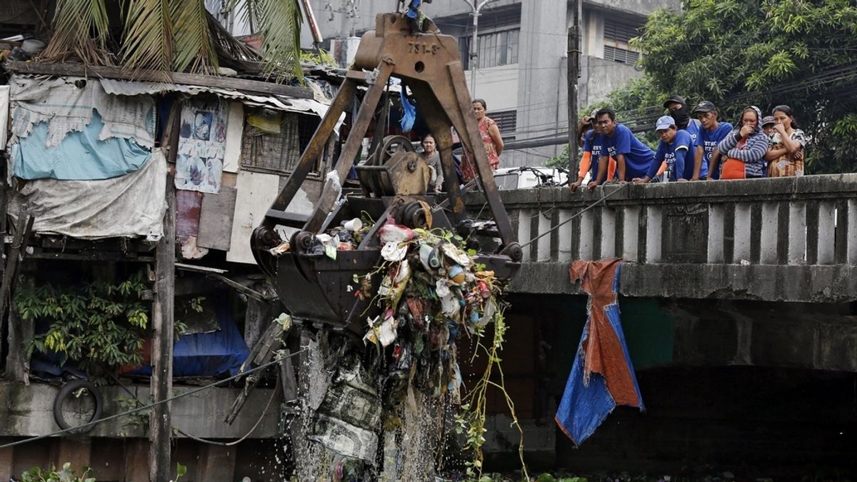 Trabajadores municipales retiran basura de un río en Manila (Filipinas)