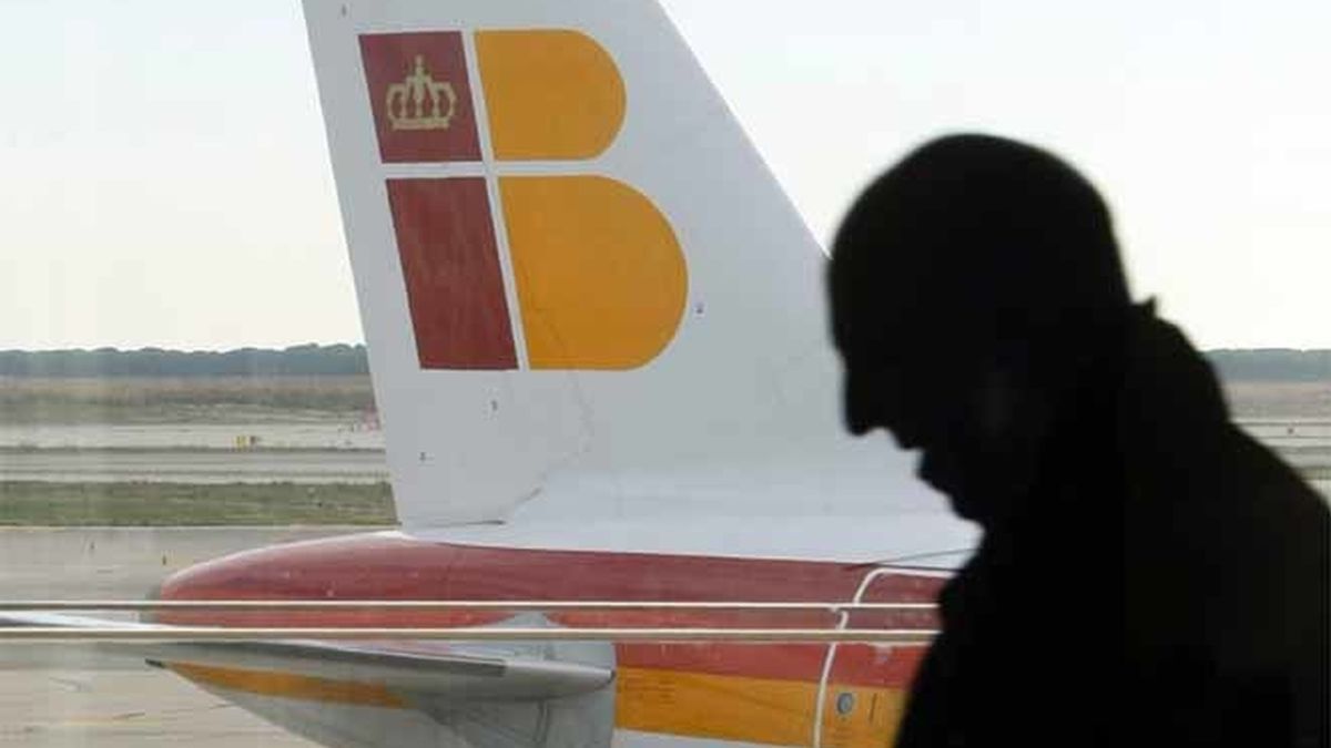Un pasajero en el aeropuerto de Barcelona con aviones de Iberia al fondo