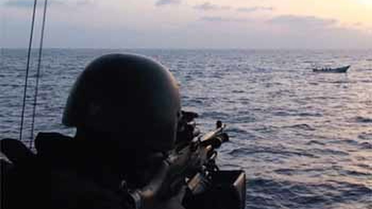 Un soldado apunta con la metralleta a piratas en el Golfo de Adén, en Somalia