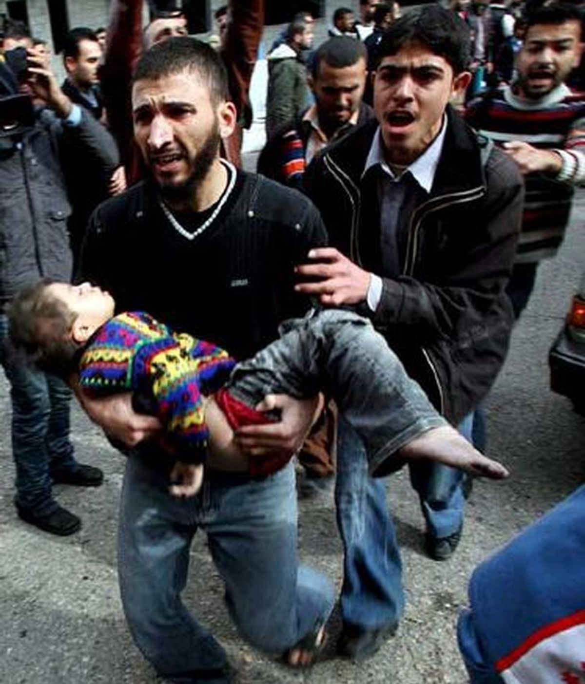 Un palestino lleva en brazos a su hijo herido tras el bombardeo de Israel a Gaza. Foto: EFE